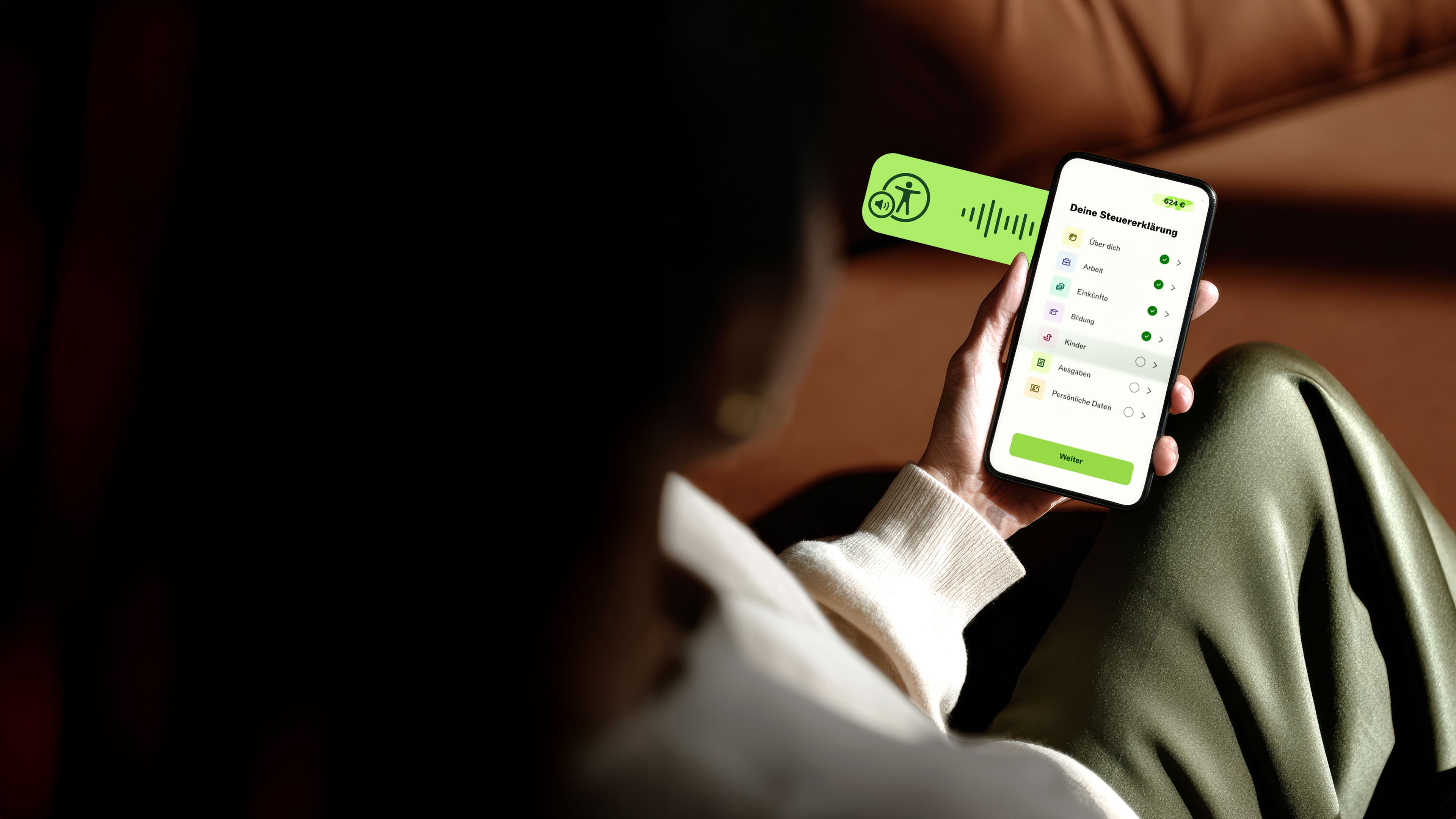 Person mit einem Smartphone, auf dem die Taxfix-App angezeigt wird. Der Text wird von der Sprachausgabefunktion vorgelesen.